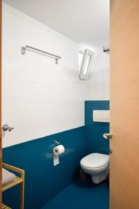 a bathroom with a toilet and a blue wall at Emmeleia Urban Apartment in Xanthi +57 photos