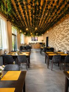 a restaurant with wooden tables and chairs and a brick wall at Aurelia Hotel & Restaurant in Dilijan