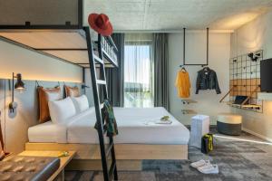 a hotel room with a bunk bed and a couch at Moxy Outletcity Metzingen in Metzingen