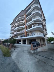 a large apartment building with a car parked in front at Emmeleia Urban Apartment in Xanthi