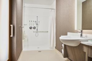 a white bathroom with a shower and a sink at SpringHill Suites by Marriott Chesterfield in Chesterfield