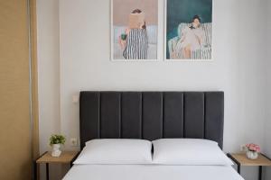 a bedroom with a bed and two pictures on the wall at Emmeleia Urban Apartment in Xanthi