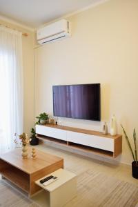 a living room with a large television on a wall at Emmeleia Urban Apartment in Xanthi