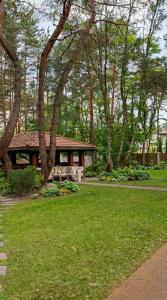 a house with a picnic table in a park at Golden Villas Luxury Garden Retreat - Jacuzzi & Sauna in Konstancin-Jeziorna