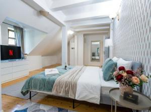 a bedroom with a large bed and a tv at Golden Villas Luxury Garden Retreat - Jacuzzi & Sauna in Konstancin-Jeziorna +65 photos
