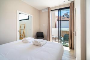 a bedroom with a white bed and a balcony at GuestReady – Steps from Sand • Champagne Pool in Machico