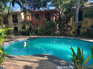 a large blue swimming pool in front of a house at Centric, clean, safe, with pool & monkey visitors in Tamarindo