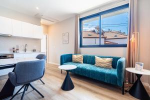 a living room with a blue couch and a kitchen at GuestReady – Steps from Sand • Champagne Pool in Machico