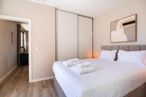 a bedroom with a white bed with towels on it at GuestReady – Steps from Sand • Champagne Pool in Machico