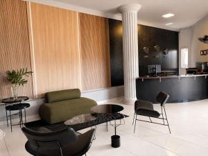 a living room with a couch and a table and chairs at Hotel Boa Viagem in Barra do Garças