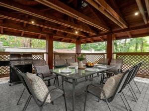 a patio with a table and chairs and a stove at Golden Villas Luxury Garden Retreat - Jacuzzi & Sauna in Konstancin-Jeziorna