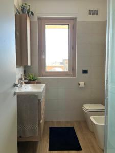 a bathroom with a sink and a toilet and a window at 081 Art corner - Milano ovest in Abbiategrasso +5 photos