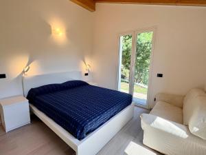 a bedroom with a bed and a couch and a window at House Over The Paradise in Moneglia +57 photos