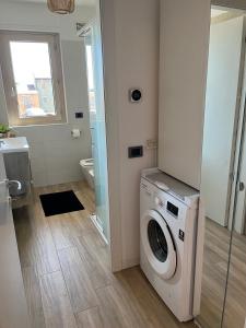 a bathroom with a washing machine and a toilet at 081 Art corner - Milano ovest in Abbiategrasso