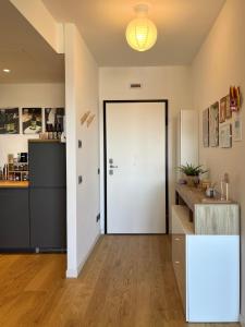 a hallway with a white door and a kitchen at 081 Art corner - Milano ovest in Abbiategrasso