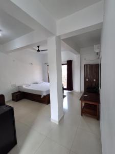 a bedroom with a bed and a table in it at Prakash Holiday Inn in Arambol