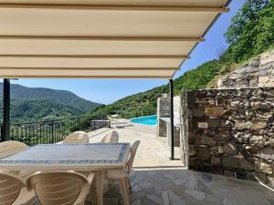 a patio with a table and chairs and a stone wall at House Over The Paradise in Moneglia