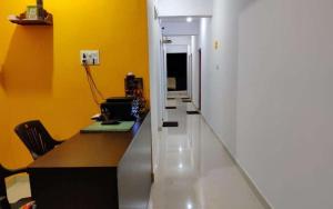 an office with a desk and a hallway with yellow walls at Prakash Holiday Inn in Arambol