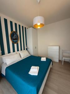 a bedroom with a blue bed with towels on it at Modern Sea Apartment in Punta Marina