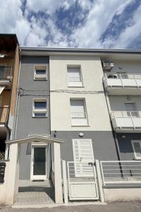 a gray and white building with white doors at Modern Sea Apartment in Punta Marina