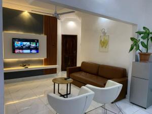 a living room with a couch and a tv at Maison d'hôte okpèyèmi in Porto-Novo