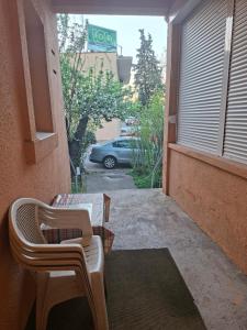 a balcony with two chairs and a car in a parking lot at Anita in Danilovgrad