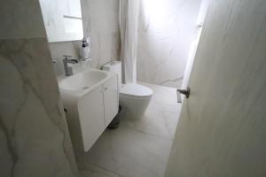 a white bathroom with a toilet and a sink at Departamento en el corazón de angelópolis in Puebla +13 photos