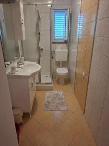 a bathroom with a toilet and a sink and a shower at Apartmani Dijana in Rab +35 photos
