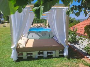 a swing bed in a yard next to a pool at Village House DIMS in Kotor