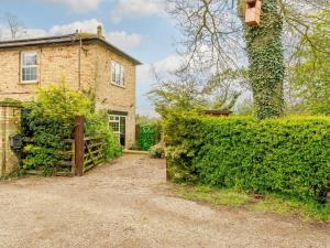 an old brick house with a gate and a hedge at 1 Bed in York oc-91888 in Full Sutton
