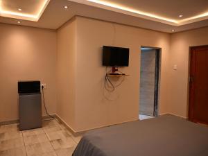 a bedroom with a bed and a television on the wall at Gae Ga Monare Guest House in Burgersfort