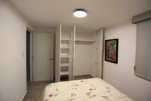 a bedroom with a bed and a book shelf at Departamento en el corazón de angelópolis in Puebla