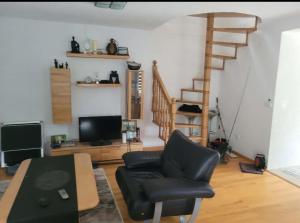 a living room with a chair and a table and stairs at Holiday home Samir in Jajce