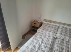 a small bedroom with a bed and a night stand at Holiday home Samir in Jajce