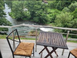 a table and chairs on a balcony with a river at Holiday home Samir in Jajce