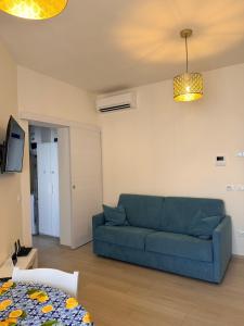 a living room with a blue couch and a table at Modern Sea Apartment in Punta Marina