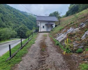 a house on a hill next to a dirt road at Holiday home Samir in Jajce +4 photos