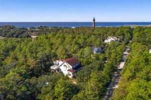 an aerial view of a house on a hill with a lighthouse at Carotank Clubhouse - Corolla Village, 200 Yds to Beach, Foosball, Pool, Hot Tub, Flex Stays in Corolla