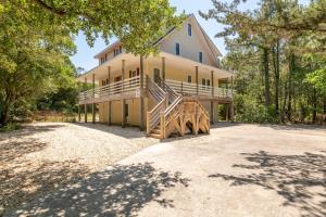 a large house with a staircase on the side of it at Carotank Clubhouse - Corolla Village, 200 Yds to Beach, Foosball, Pool, Hot Tub, Flex Stays in Corolla