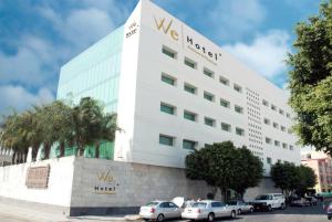 a white building with a wvu hotel sign on it at We Hotel Aeropuerto in Mexico City