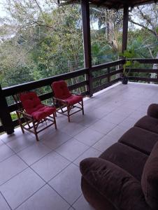 a living room with two chairs and a couch on a porch at Casa indaial in Indaial