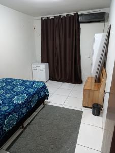 a bedroom with a bed and a dresser and a window at Casa indaial in Indaial