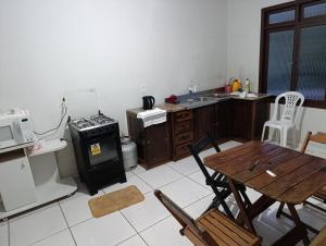 a kitchen with a wooden table and a stove at Casa indaial in Indaial