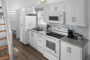 a kitchen with white cabinets and a white refrigerator at Sun Outdoors Petoskey Bay Harbor in Petoskey