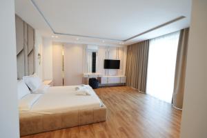 a large bedroom with a bed and a television at Palmera Prive Vila in Sarandë +46 photos