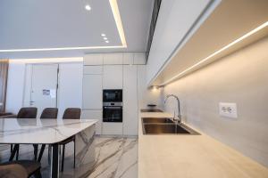 a kitchen with a sink and a table with chairs at Palmera Prive Vila in Sarandë