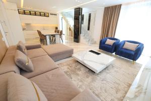 a living room with a couch and a table at Palmera Prive Vila in Sarandë