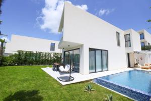 a white house with a swimming pool and a yard at Palmera Prive Vila in Sarandë