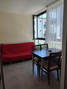 a living room with a red couch and a table and chairs at Umut's Hause in Bezkesen