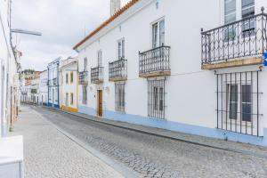 an empty street with white and blue buildings at Solar de Arrayollos by PURUS in Arraiolos